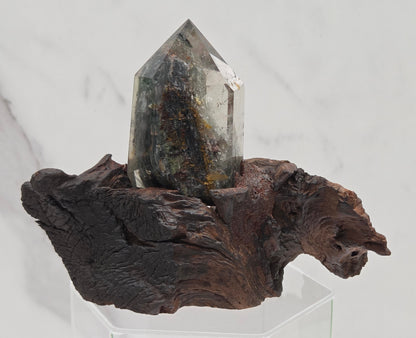 Garden Quartz crystal tower on top of  a driftwood base, set against a light background.