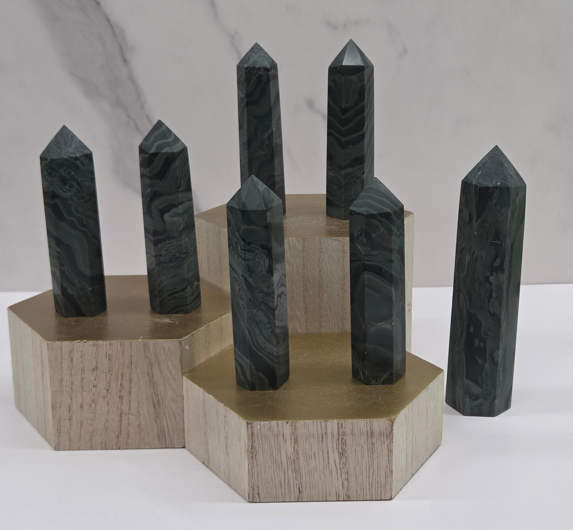 Set of green wave picture jasper towers on a wood base on a white background