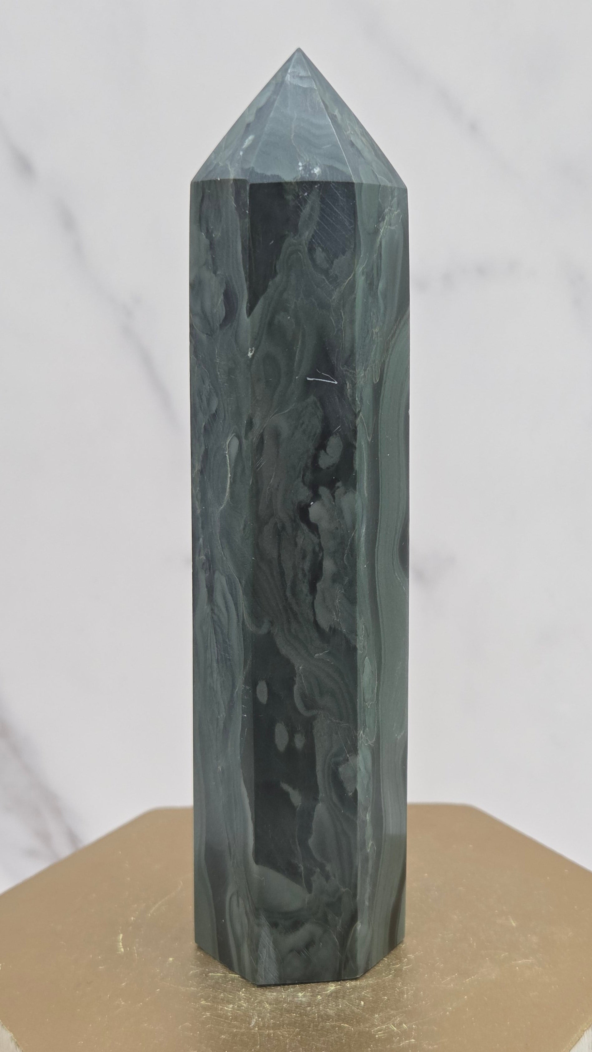 Green wave picture jasper tower on a wood base on a white background