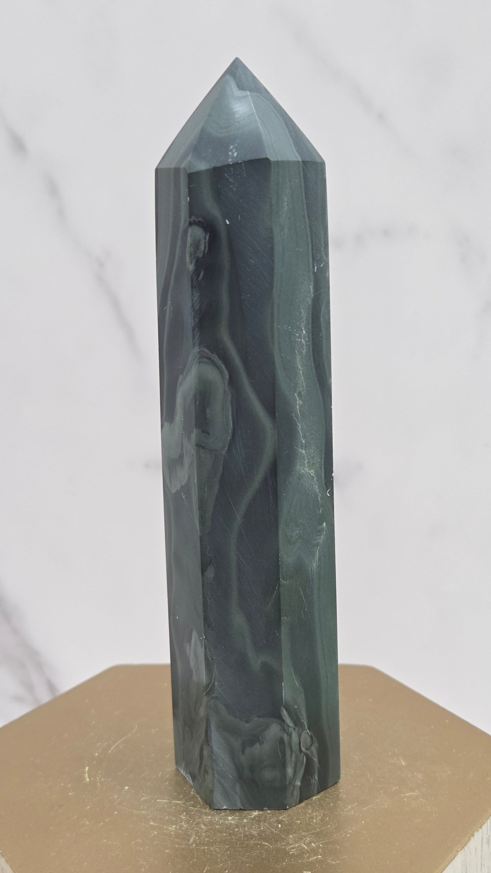 Green wave picture jasper tower on a wood base on a white background