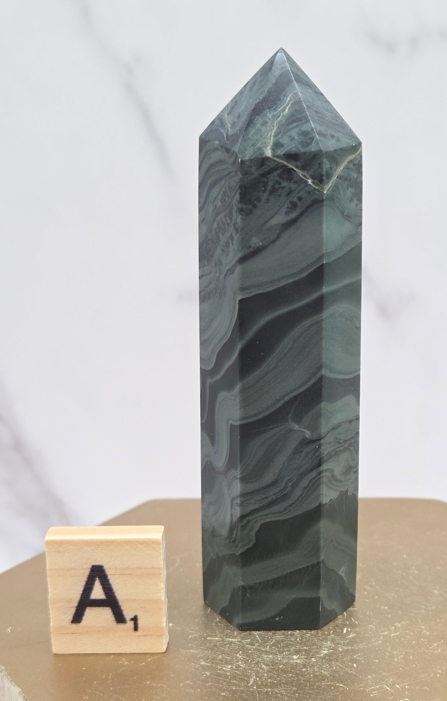 Green wave picture jasper tower on a wood base on a white background