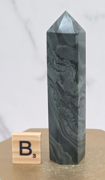 Green wave picture jasper tower on a wood base on a white background