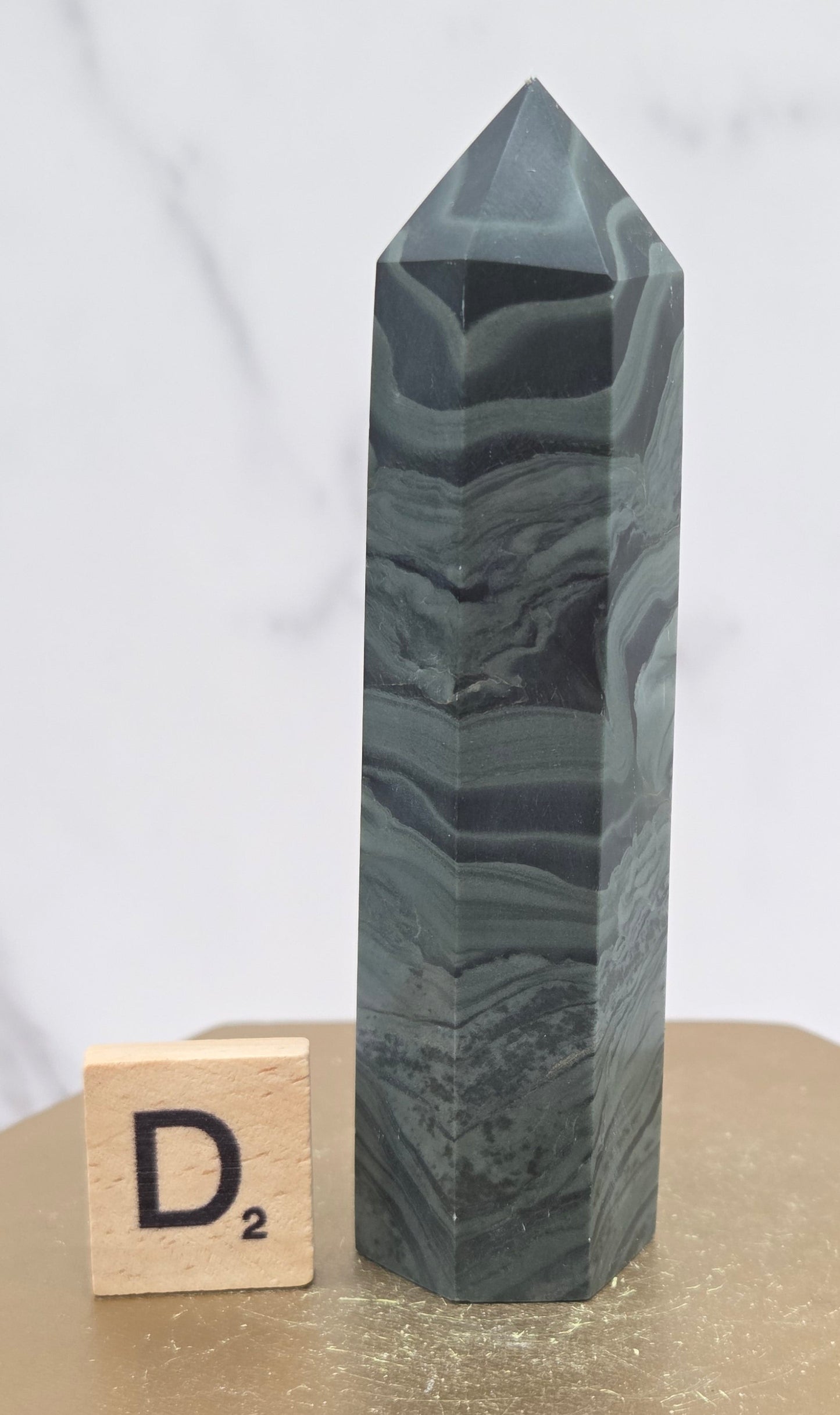 Green wave picture jasper tower on a wood base on a white background