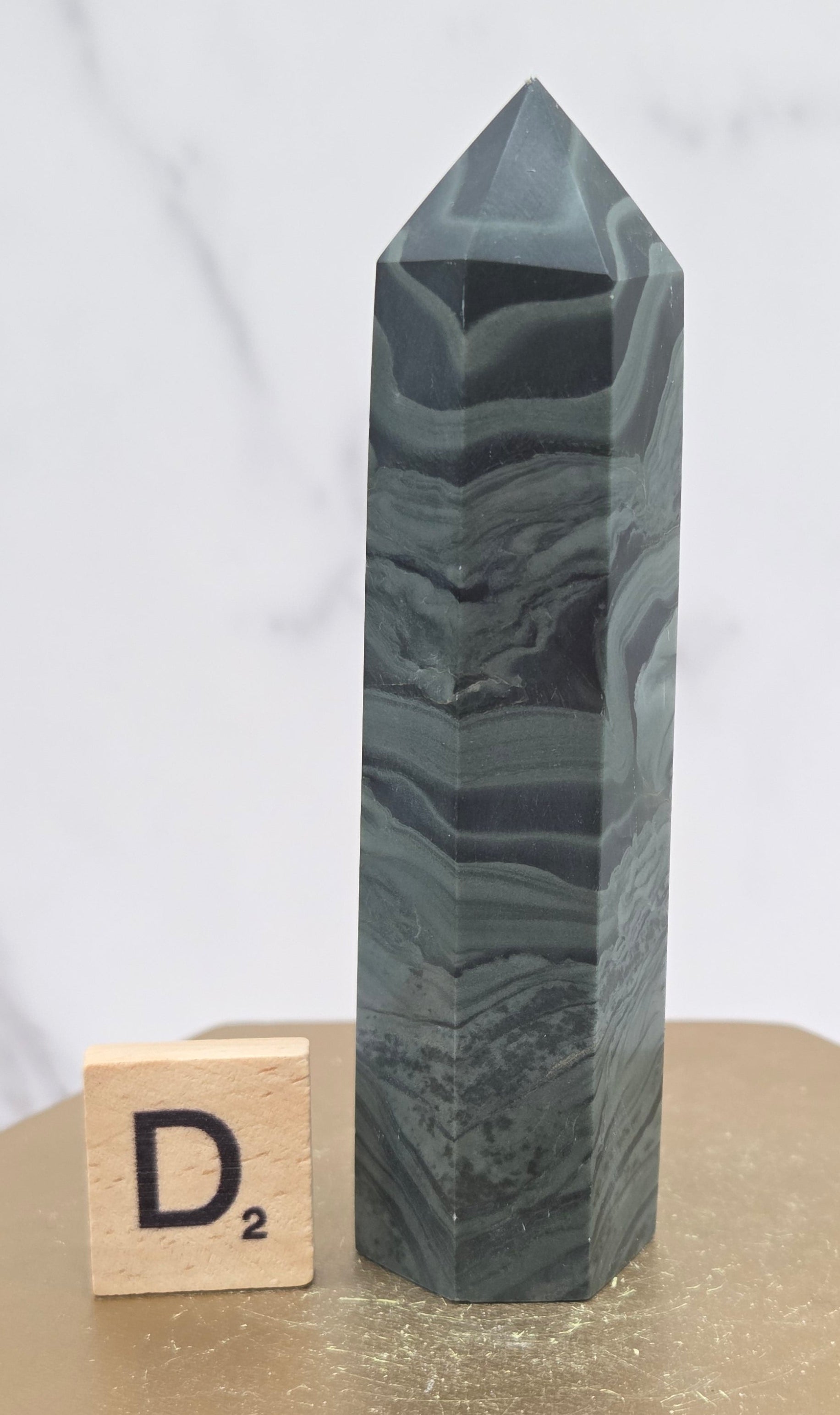 Green wave picture jasper tower on a wood base on a white background