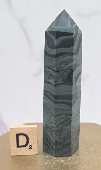 Green wave picture jasper tower on a wood base on a white background
