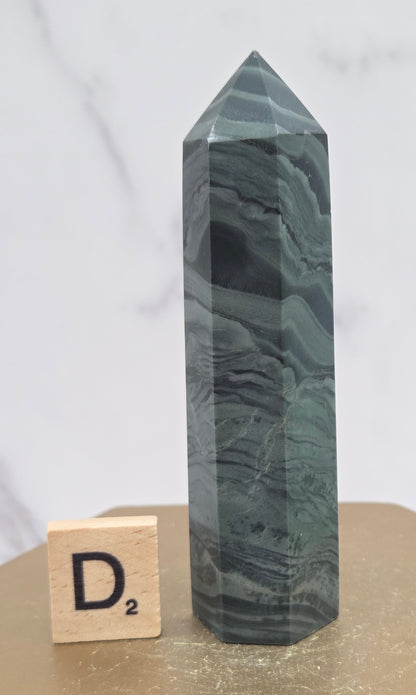 Green wave picture jasper tower on a wood base on a white background