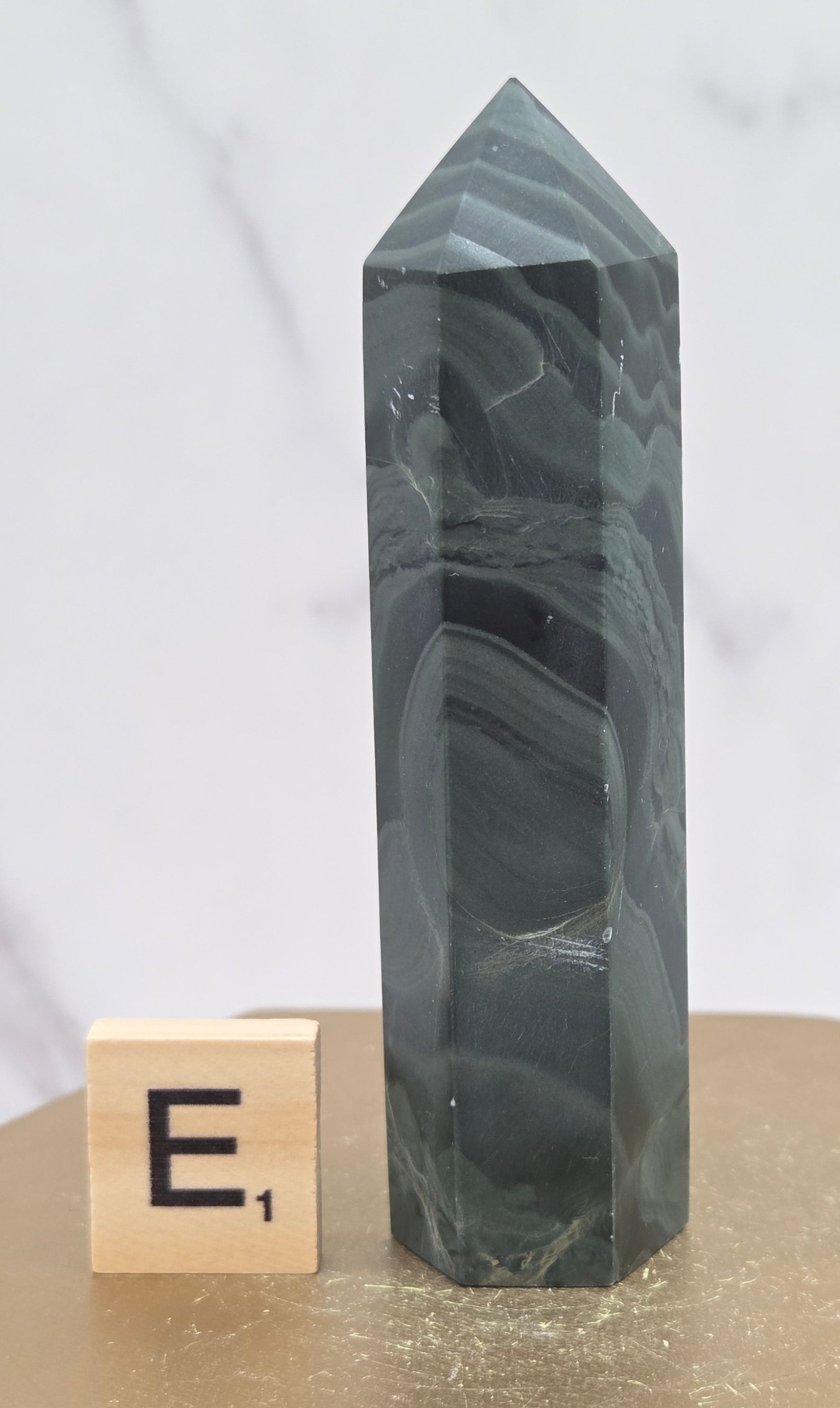 Green wave picture jasper tower on a wood base on a white background