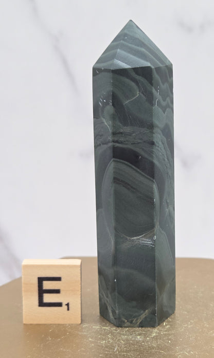 Green wave picture jasper tower on a wood base on a white background