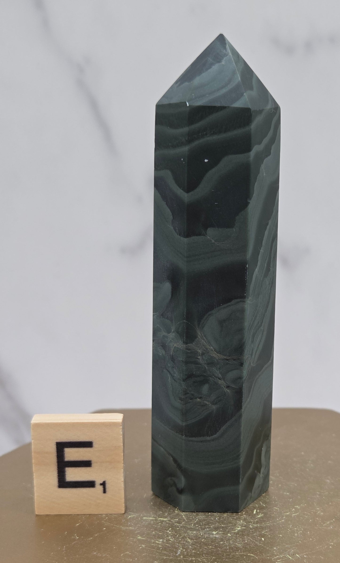 Green wave picture jasper tower on a wood base on a white background