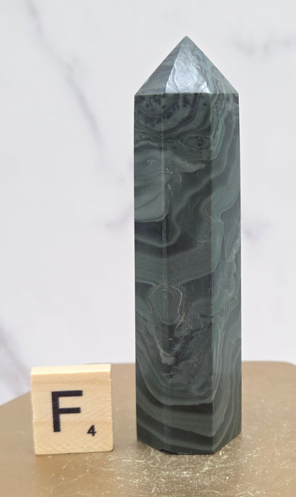 Green wave picture jasper tower on a wood base on a white background