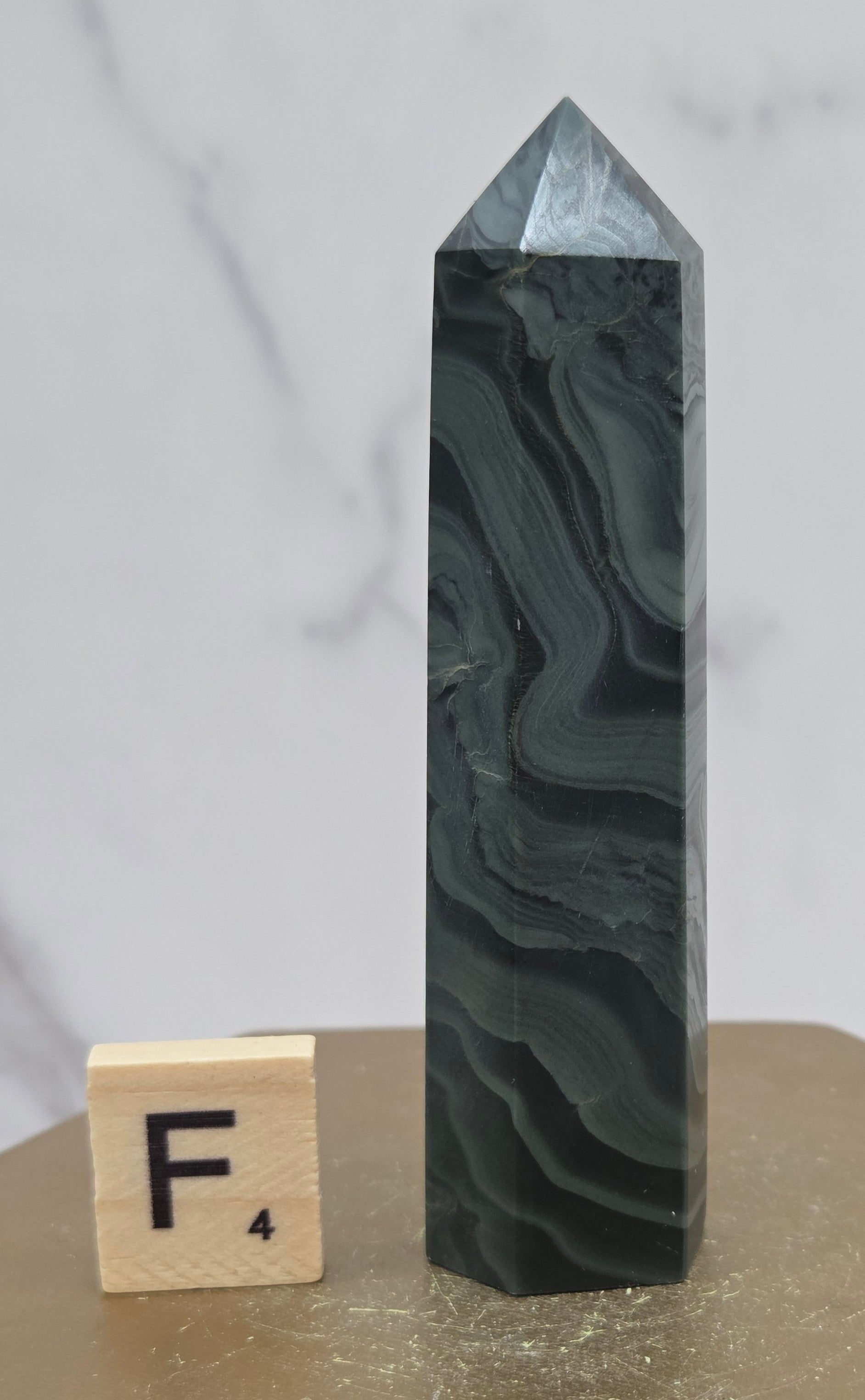 Green wave picture jasper tower on a wood base on a white background