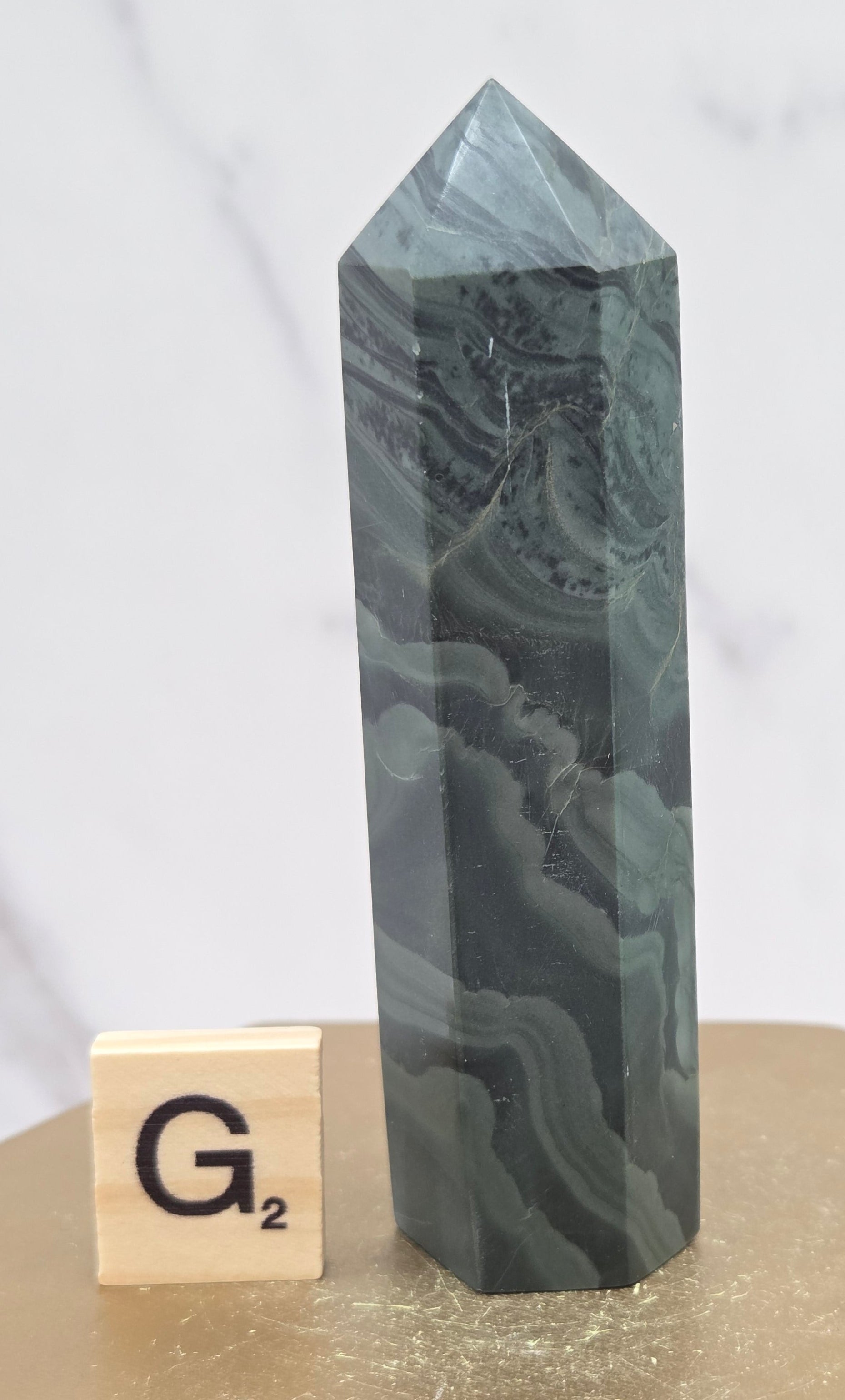 Green wave picture jasper tower on a wood base on a white background
