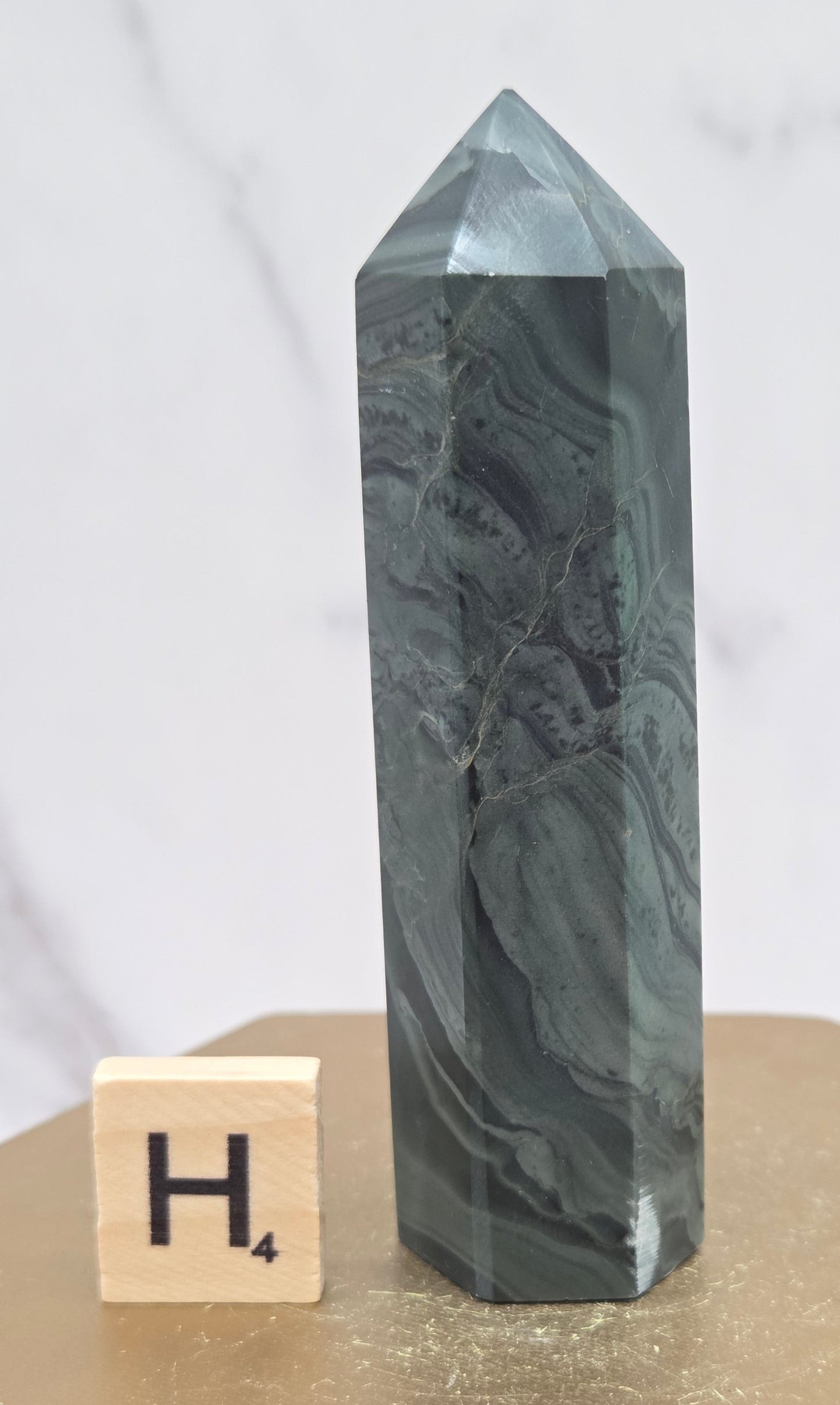 Green wave picture jasper tower on a wood base on a white background