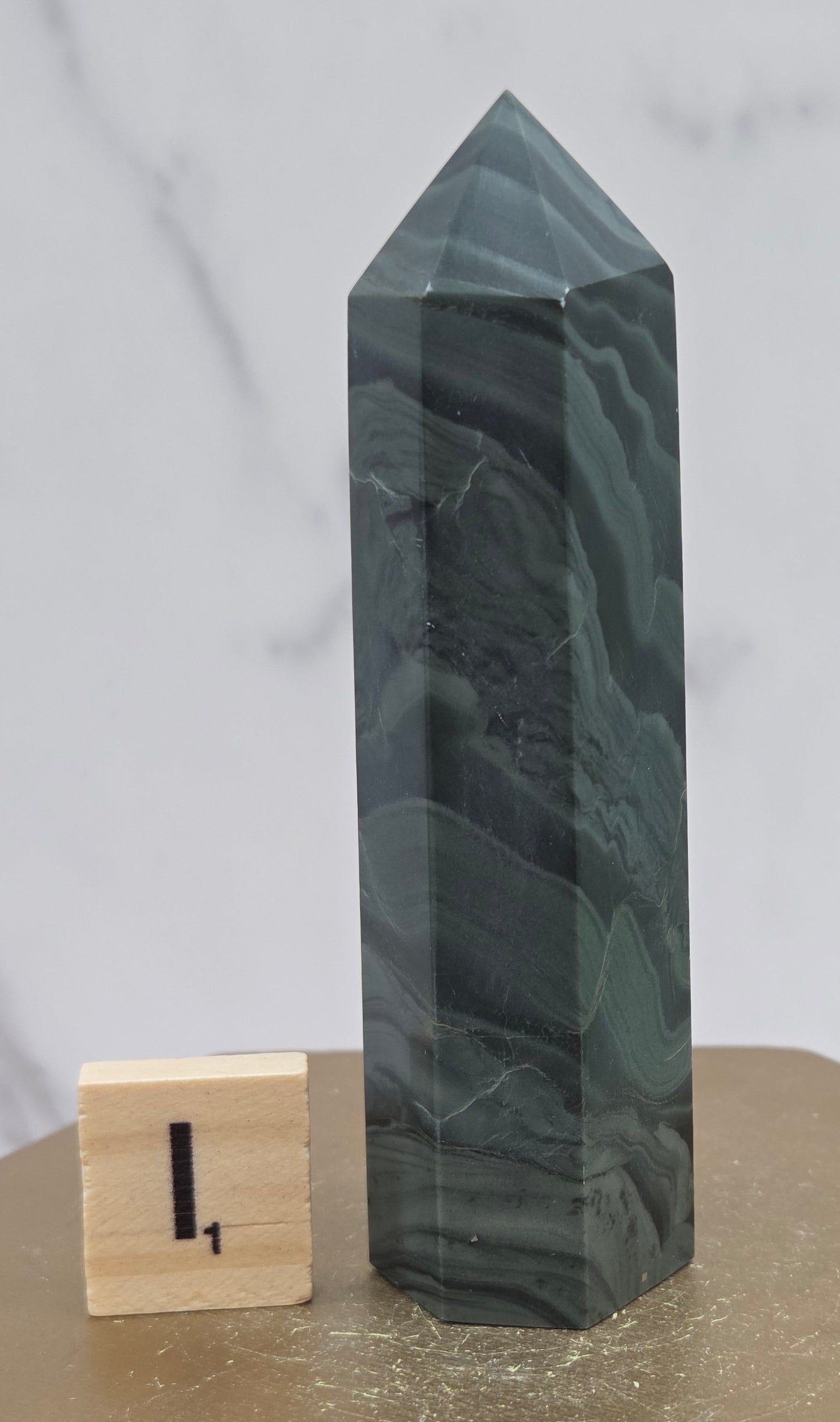 Green wave picture jasper tower on a wood base on a white background