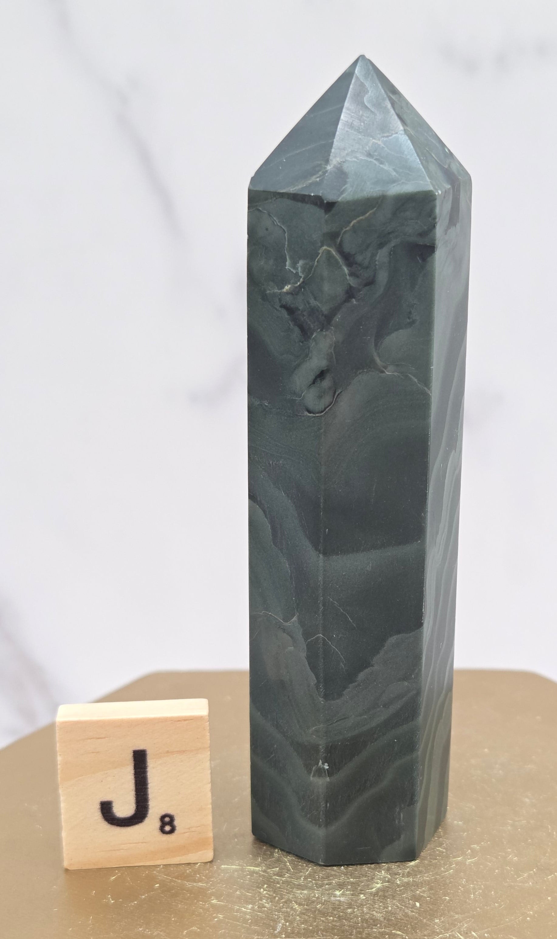Green wave picture jasper tower on a wood base on a white background