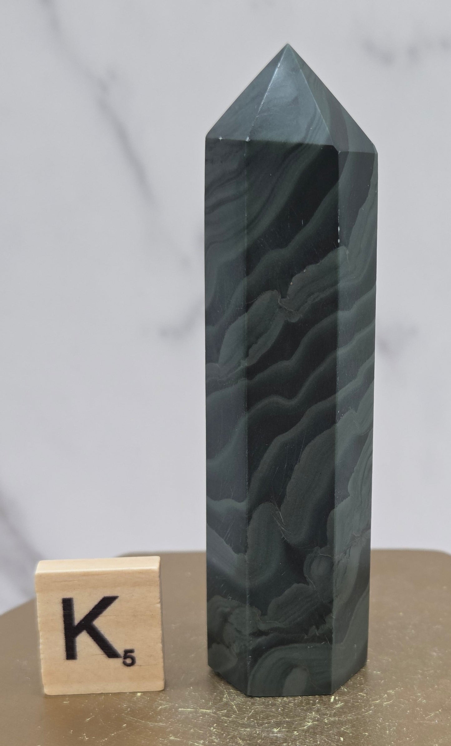 Green wave picture jasper tower on a wood base on a white background