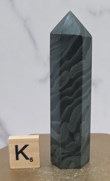 Green wave picture jasper tower on a wood base on a white background