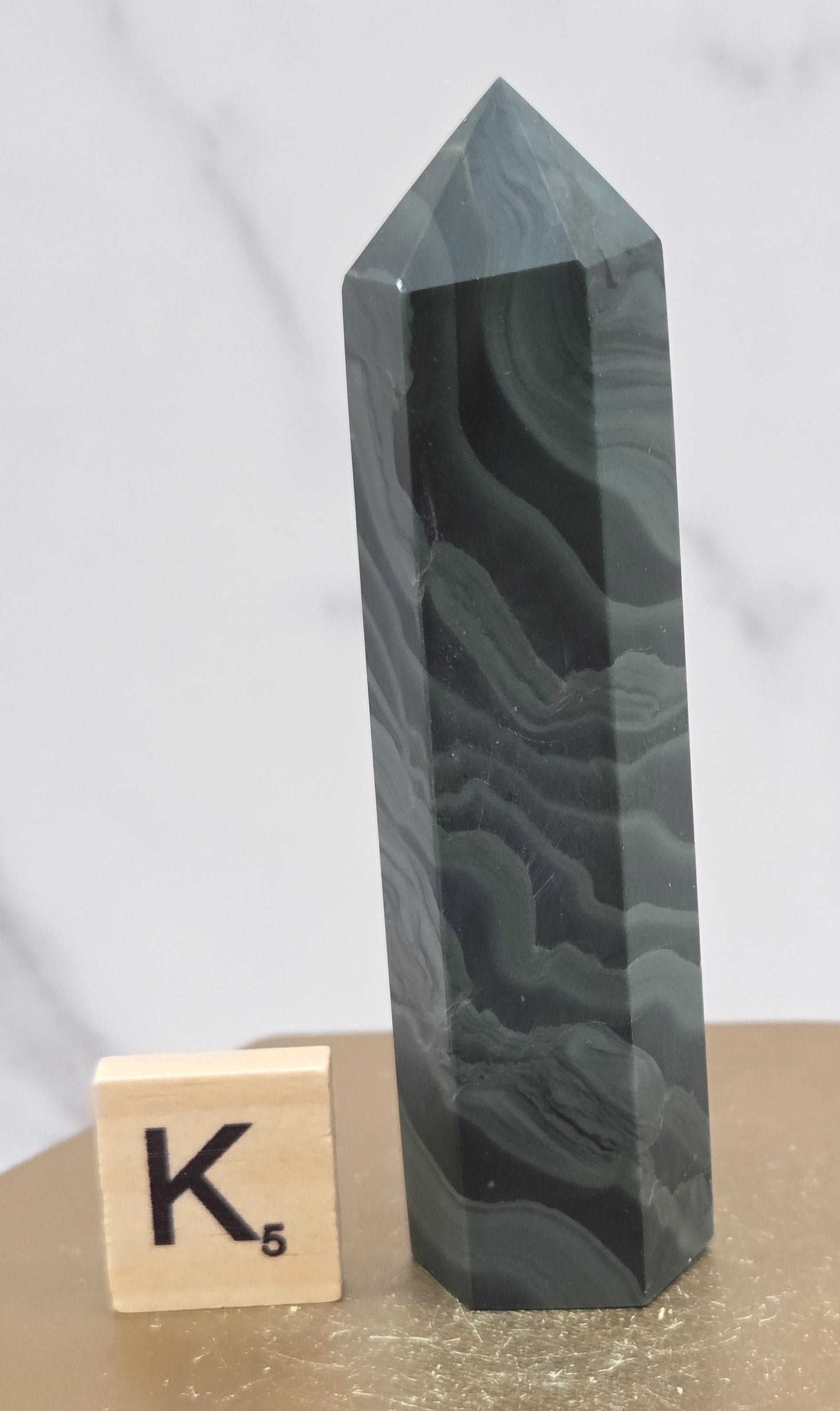 Green wave picture jasper tower on a wood base on a white background
