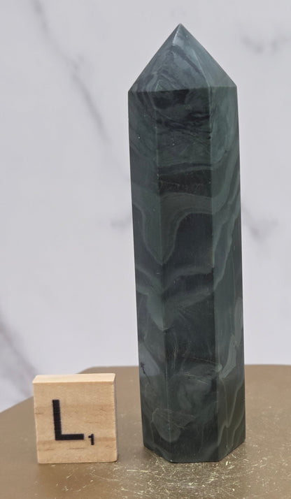 Green wave picture jasper tower on a wood base on a white background