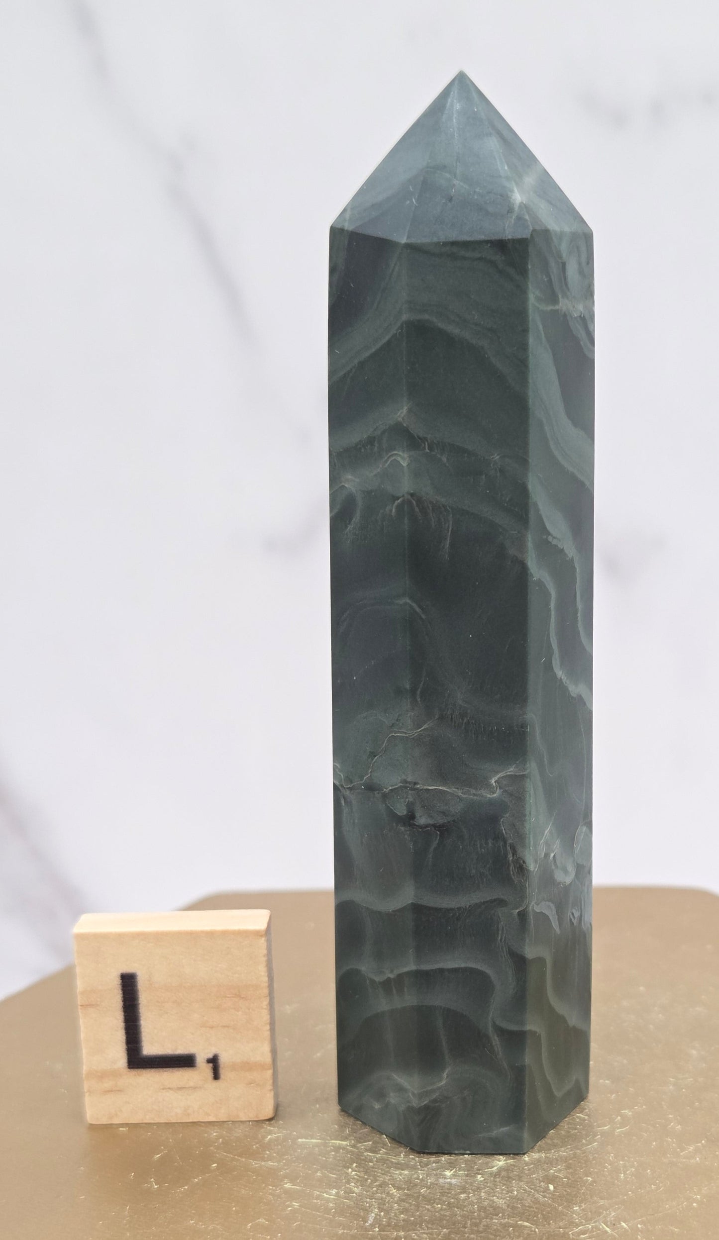 Green wave picture jasper tower on a wood base on a white background