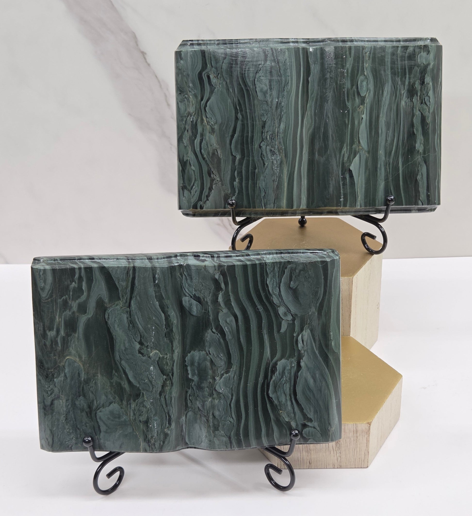 Set of green wave picture jasper carvings made to resemble an open book, on stands, on a white background. Books have wave-like patterns.