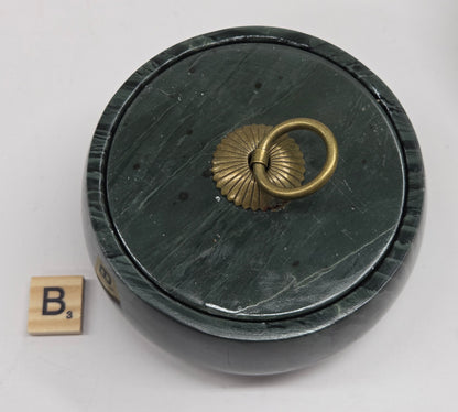 Round bowl container, with a gold colored handle on the lid, made of green wave picture jasper, with wave like patterns, on a white background