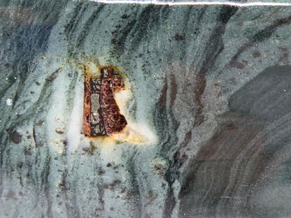 Close-up of green wave picture jasper with wave like patterns and a pyrite inclusion