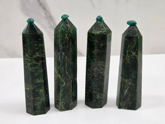 Set of 4 green emerald towers with yellow and black inclusions, on a white background