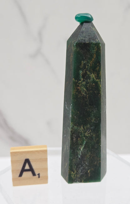 Green emerald towers with yellow and black inclusions, on a white background