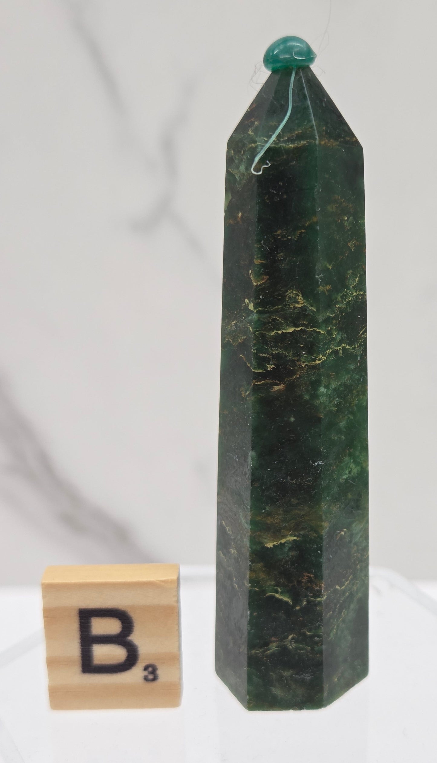 Green emerald towers with yellow and black inclusions, on a white background