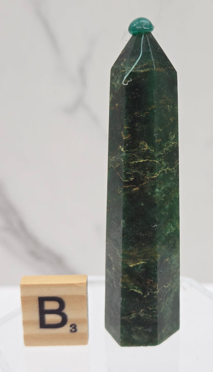 Green emerald towers with yellow and black inclusions, on a white background