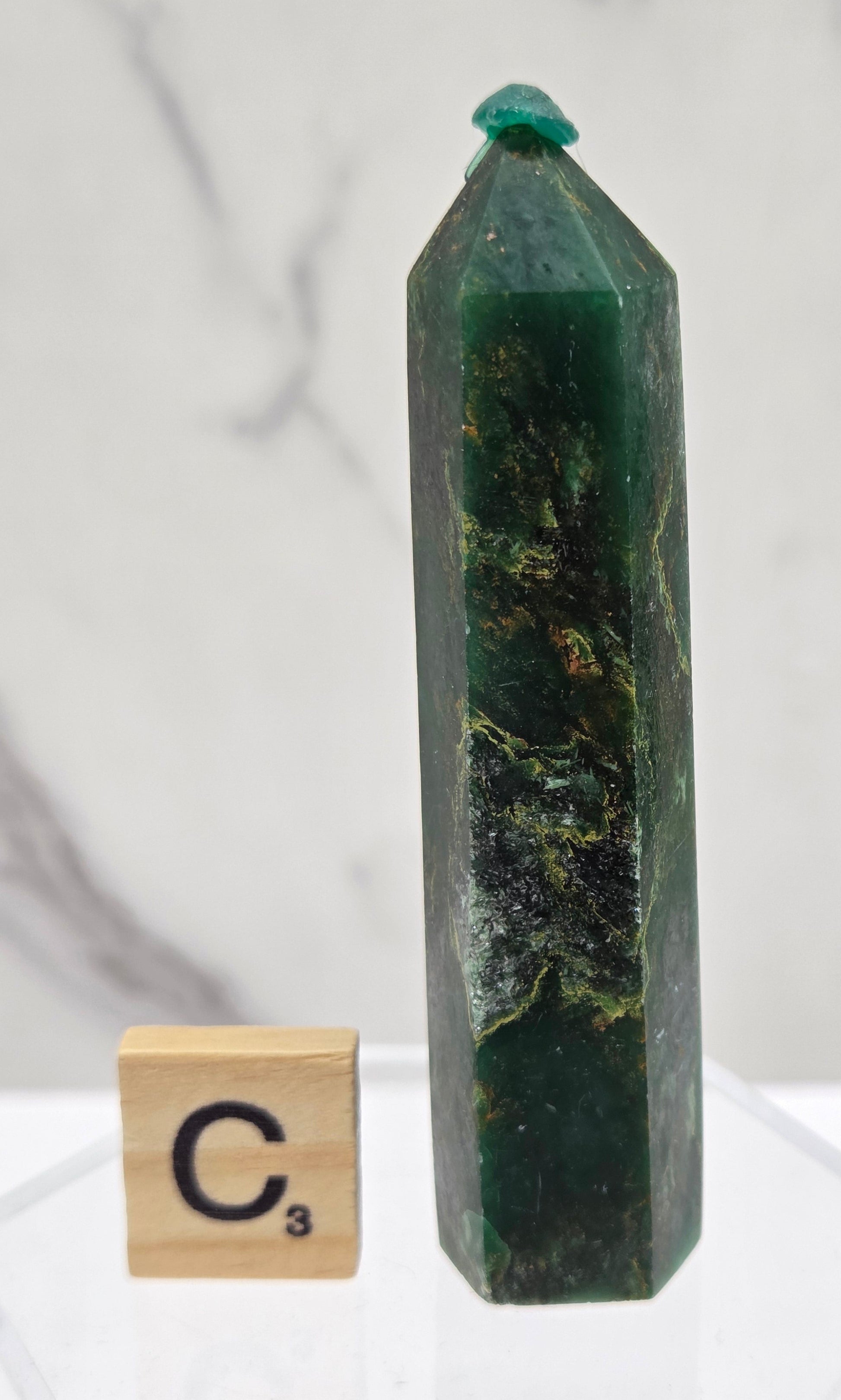 Green emerald towers with yellow and black inclusions, on a white background