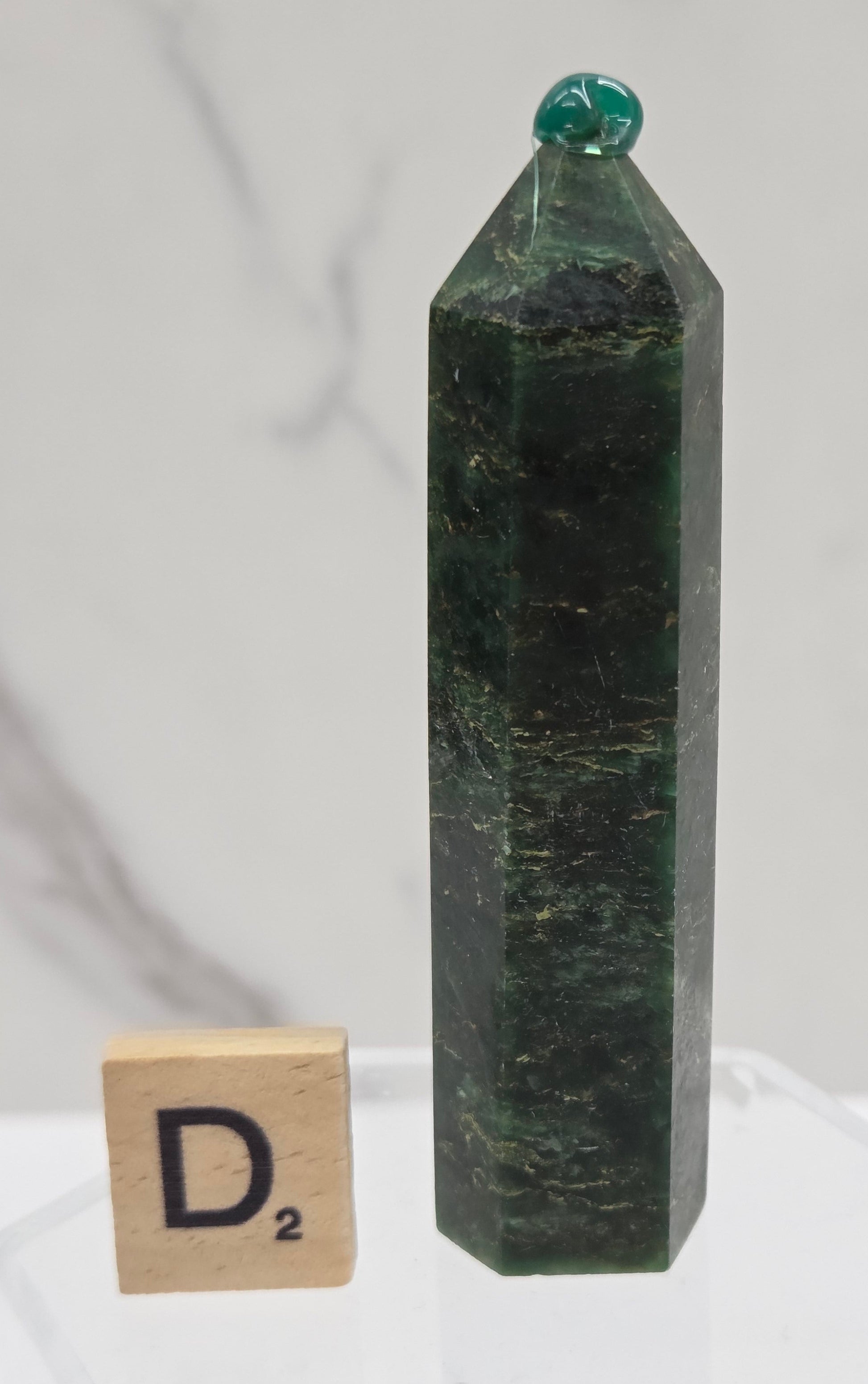 Green emerald towers with yellow and black inclusions, on a white background