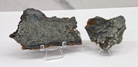 Mineral slabs of agate with marcasite on a stand on a white background