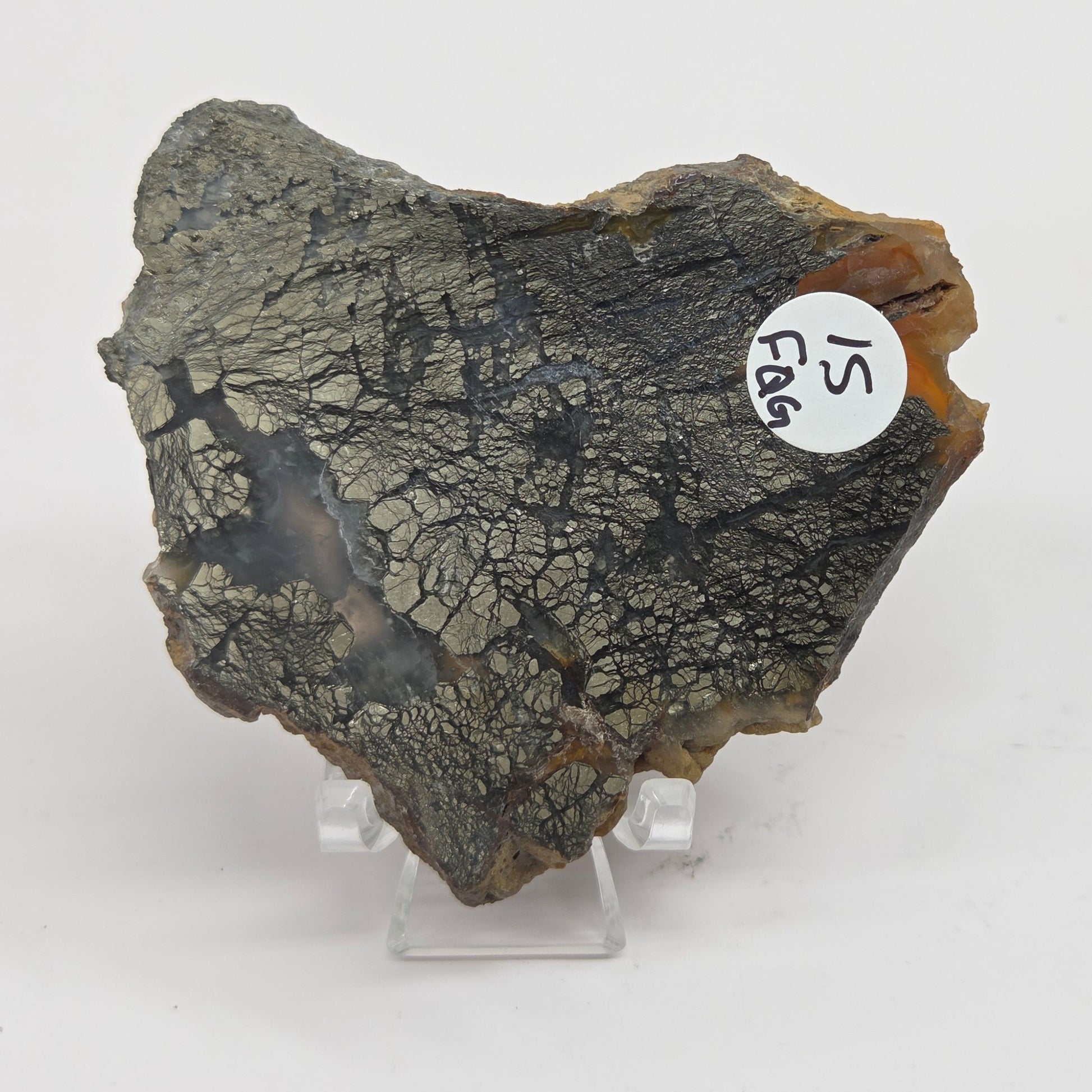 Mineral slab of agate with marcasite on a stand on a white background