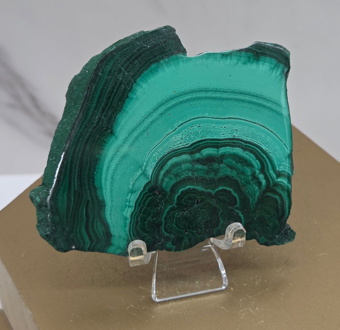 Green malachite crystal on a hexagonal brown base with a white background