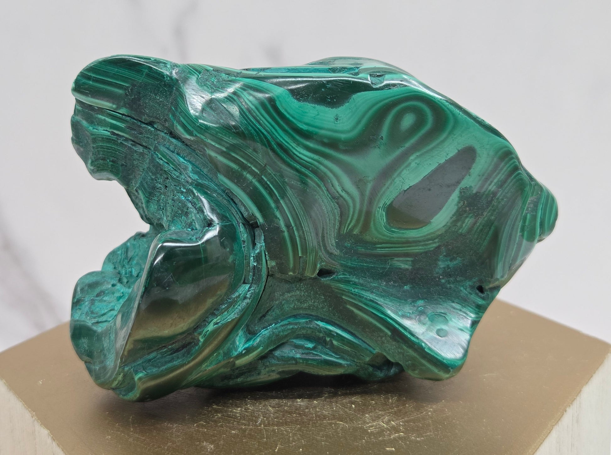 Green Malachite stone on a wood stand and a white background