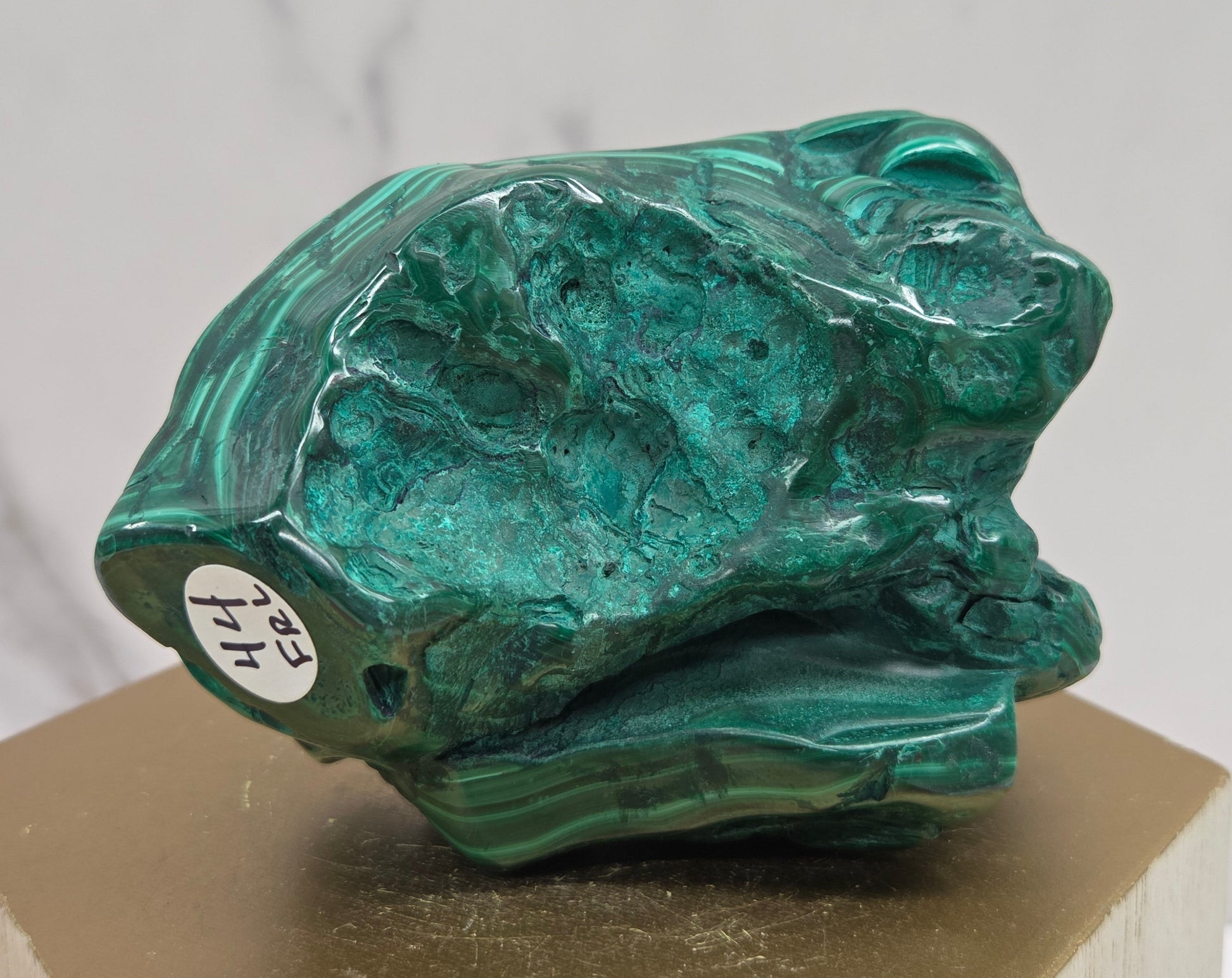 Green Malachite stone on a wood stand and a white background