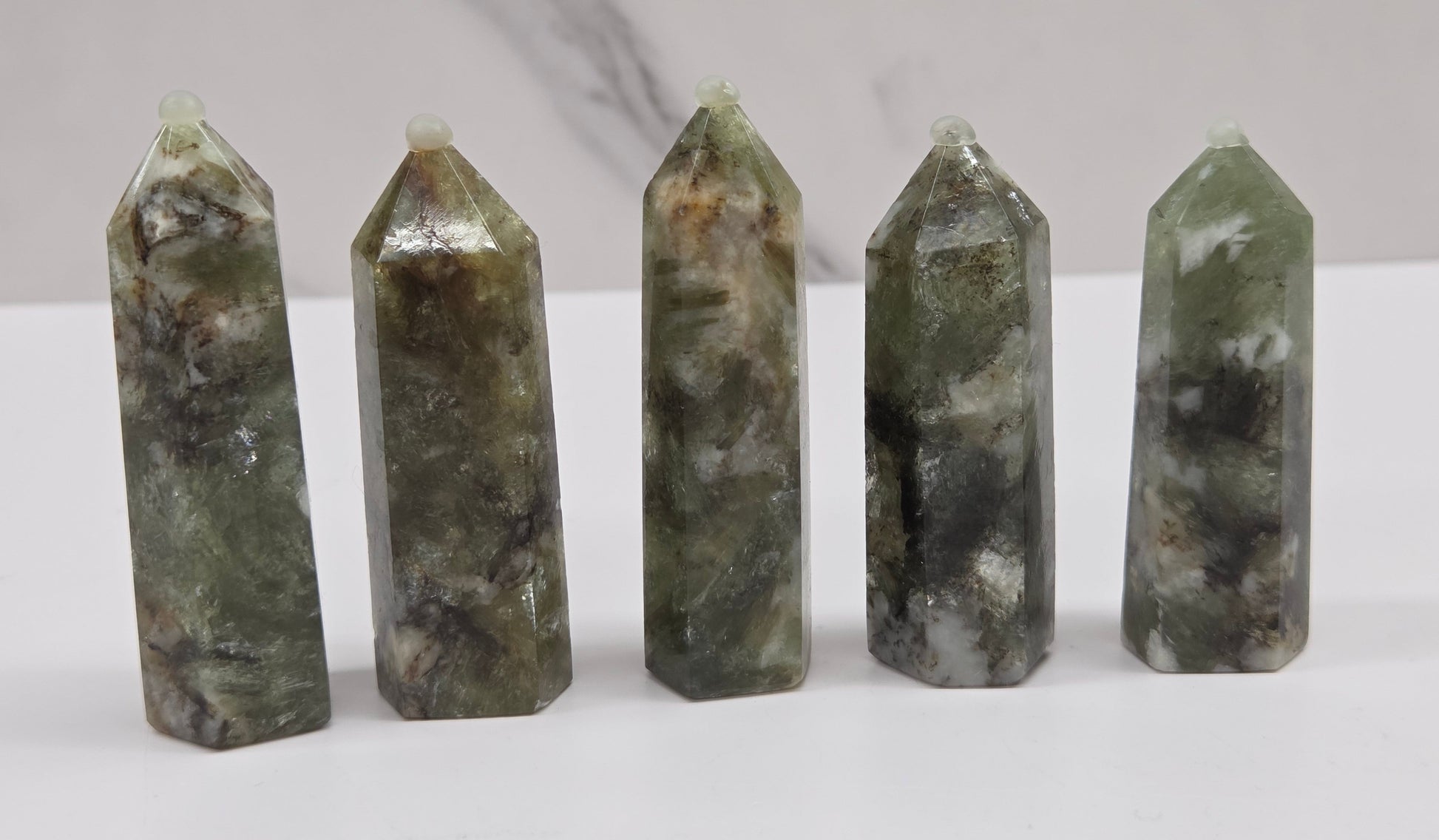 set of Green mica in quartz towers with black and white inclusions, on a white background
