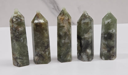 set of Green mica in quartz towers with black and white inclusions, on a white background
