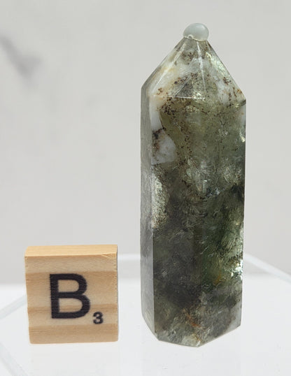Crystal tower on a white stand with a wooden block labeled 'B3' against a light gray background