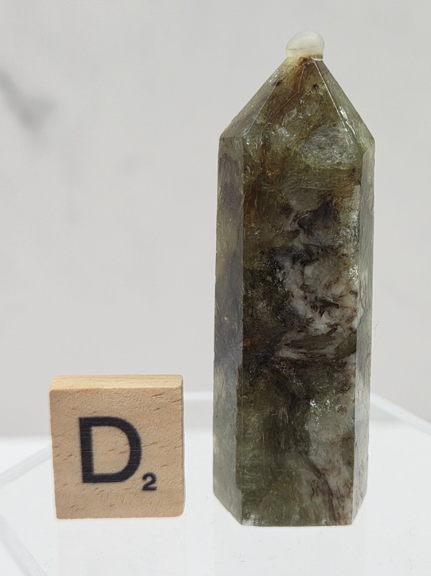 Crystal tower on a stand with a wooden block labeled 'D2' against a white background