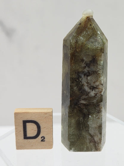 Crystal tower on a stand with a wooden block labeled 'D2' against a white background