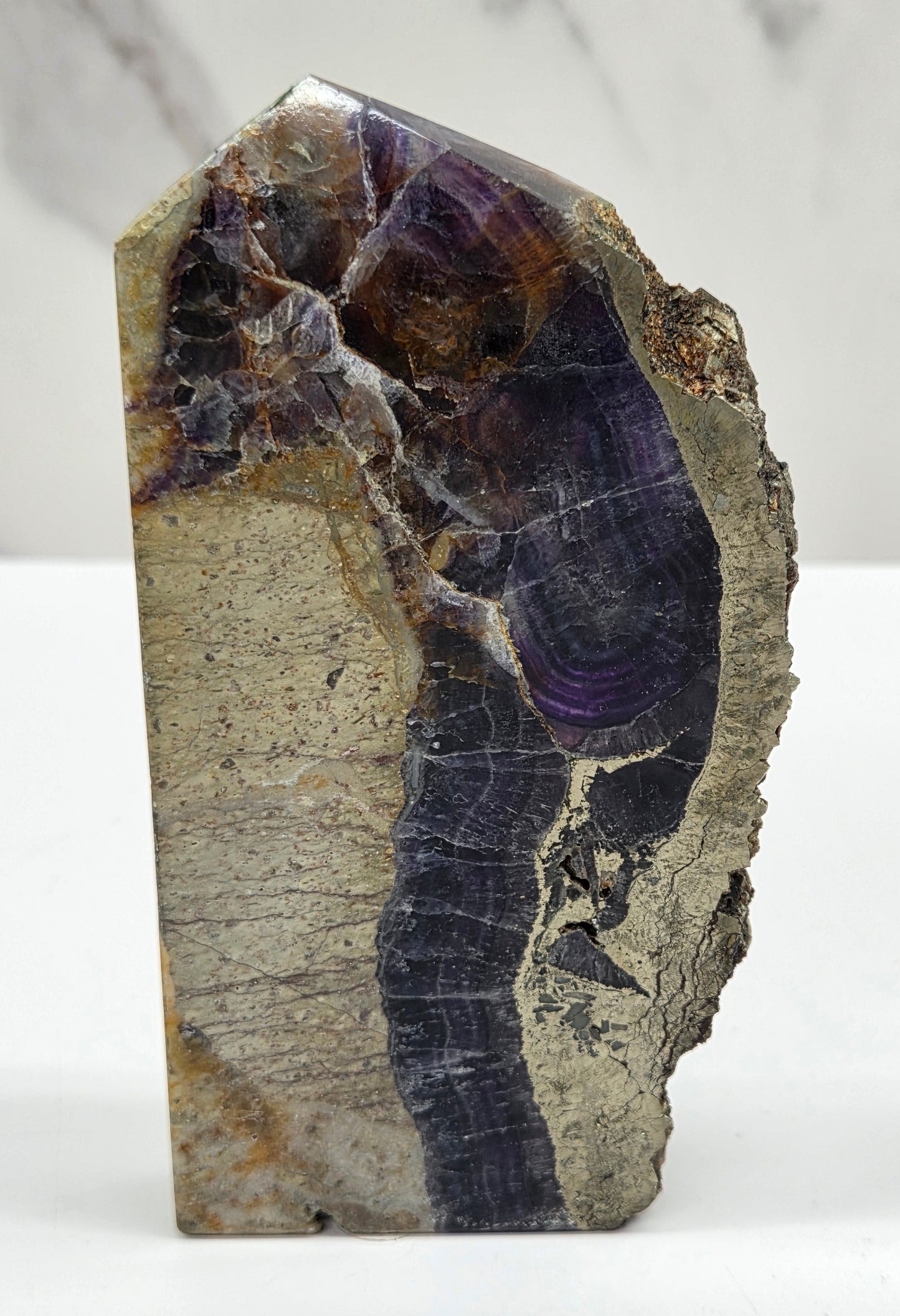 Fluorite tower with pyrite edges on a white background