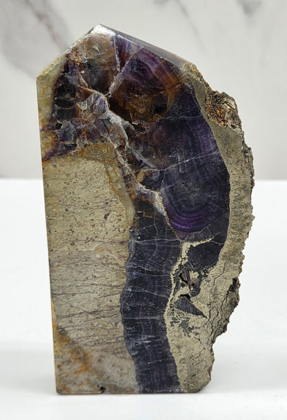 Fluorite tower with pyrite edges on a white background