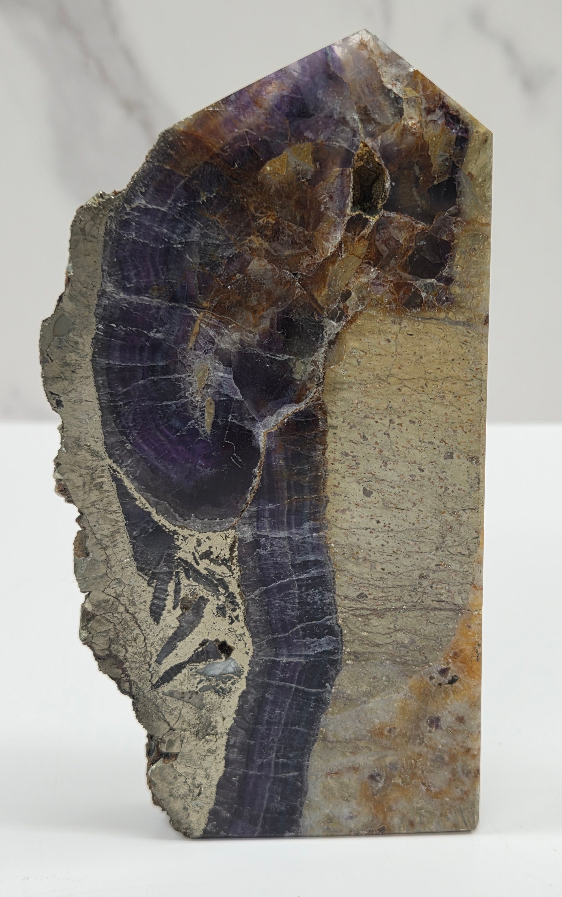 Fluorite tower with purple and brown crystals on a white background