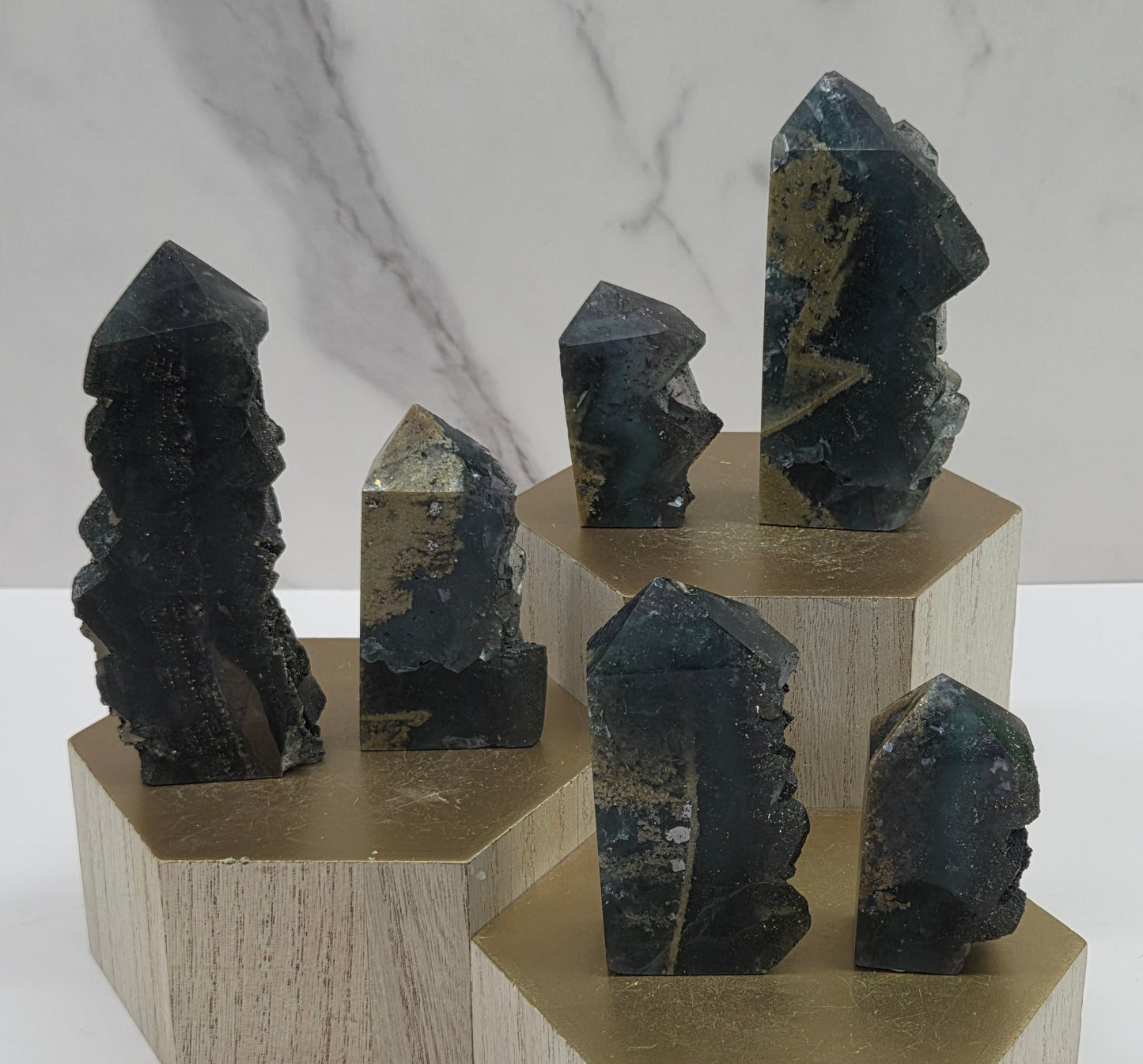 Set of variety of fluorite towers on a wood stand and white background