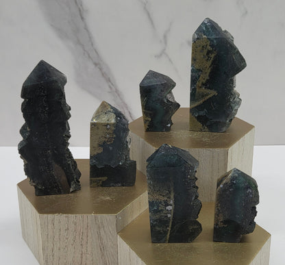 Set of variety of fluorite towers on a wood stand and white background