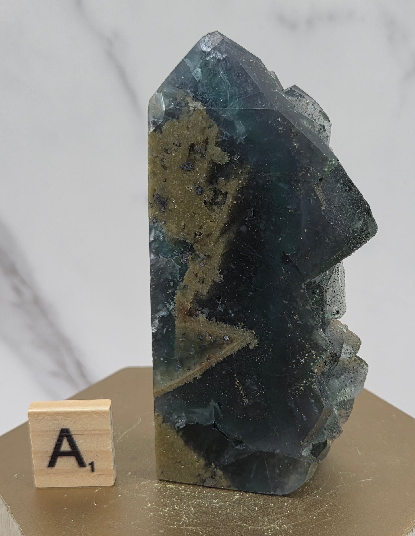 Fluorite crystal on a wooden stand with a marble background