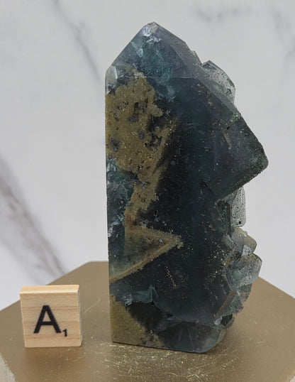 Fluorite crystal on a wooden stand with a marble background